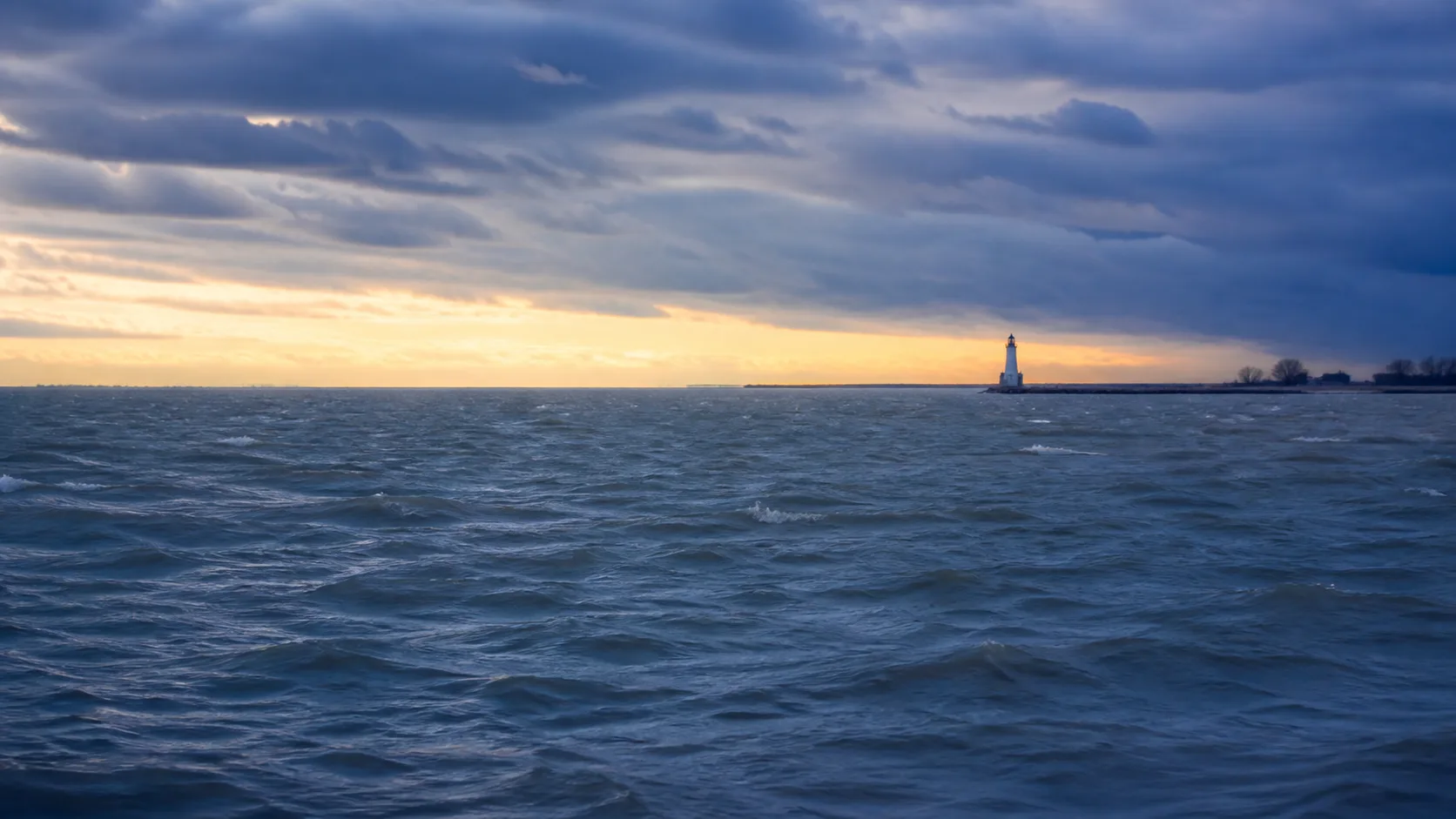 Illustrative wind-driven waves beneath changing clouds on Lake Erie
